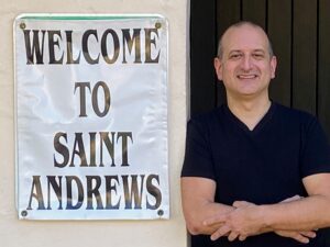Rob standing nest to Welcome to Saint Andrews sign